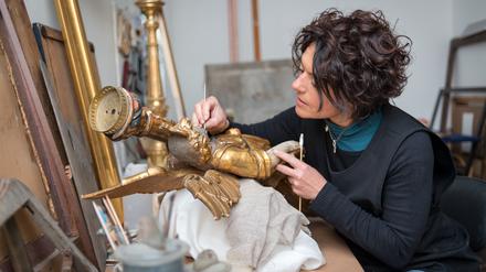 Restaurierung einer antiken goldenen Engelsstatue.