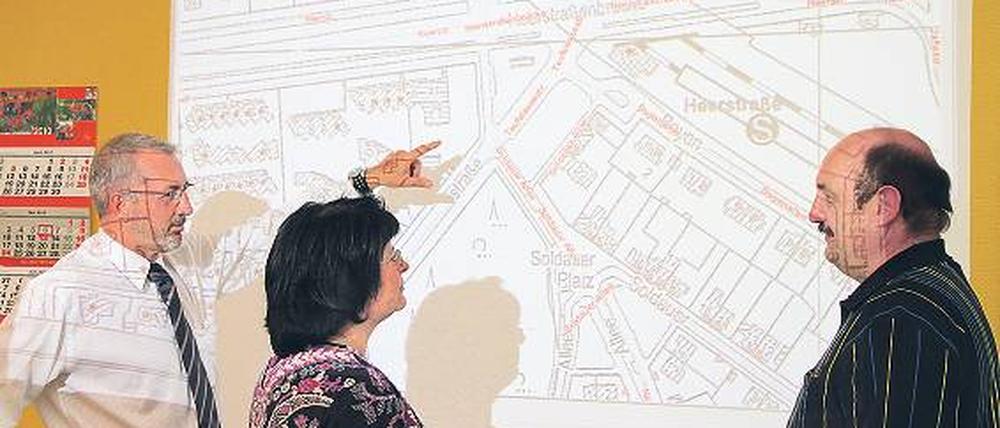 Effektives Tüfteln. Die Logistiker Ralf Ränker, Carola Assmann und Klaus-Peter Gerdum von der BSR (v.l.) planen effiziente Routen für Müllfahrzeuge. Ein an die Wand projizierter Stadtplan, auf dem jedes Grundstück mit Tonnen oder Containern verzeichnet ist, hilft ihnen dabei.