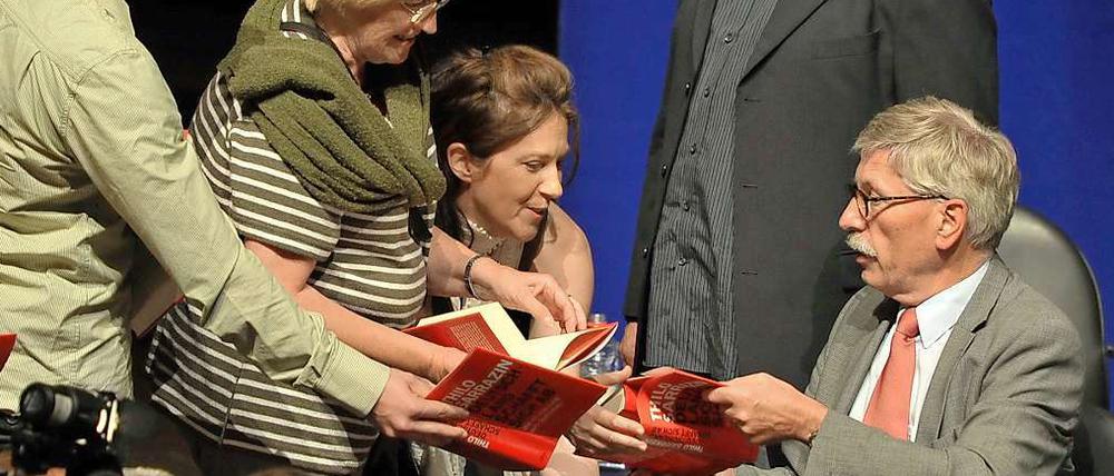 Thilo Sarrazin (r) signiert in Potsdam im Nikolaisaal Exemplare seines Buches.