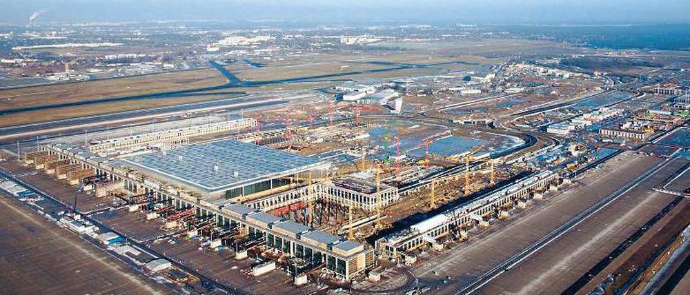 Noch eineinhalb Jahre. Hinten in der Ferne ist noch der alte, jetzige Flughafen zu erkennen, im Juni 2012 wird der neue, sechsstöckige Airport eröffnet. Um die Dimensionen der Baustelle zu verdeutlichen: Die Fassade des Terminals (vorn) ist 715 Meter lang. Zwischen beiden Rollbahnen liegen fast zwei Kilometer.