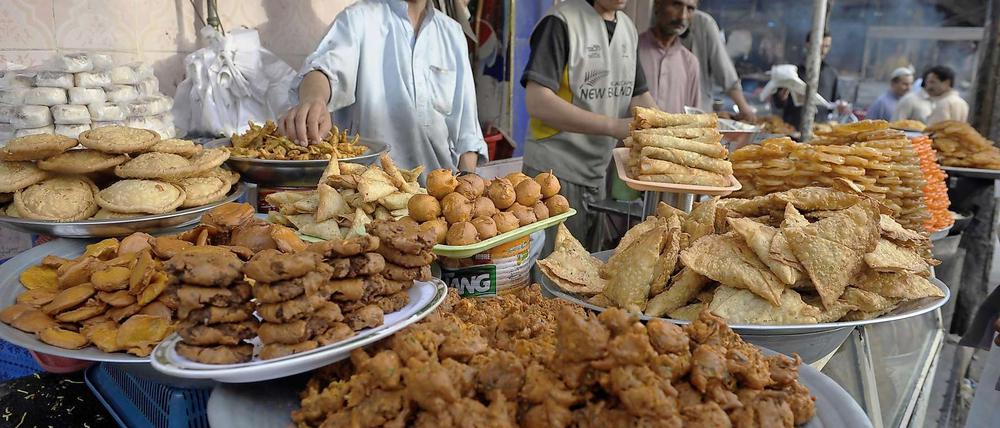 Nach Sonnenuntergang darf wieder gespeist werden: Pakistanische Händler bauen schon mal ihren Stand mit den traditionellen Iftar auf.
