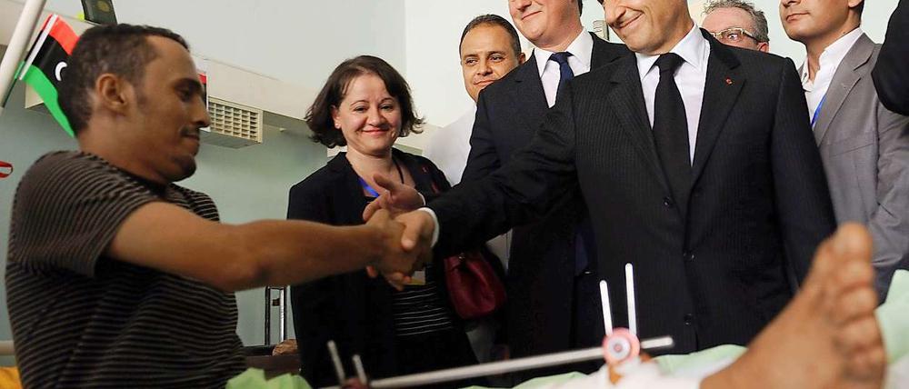 David Cameron (li.) besucht mit Nicolas Sarkozy einen Verletzten in einem Krankenhaus in Tripolis.