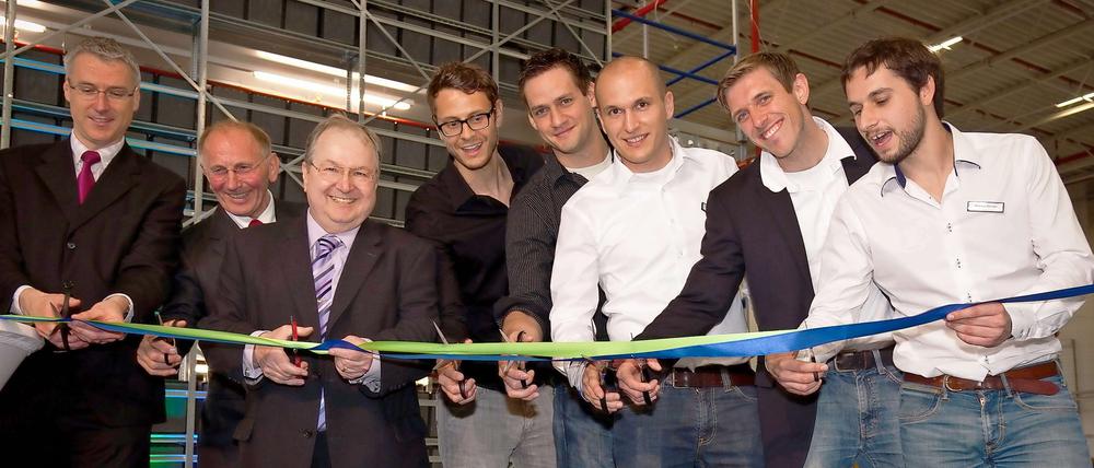 Acht Männer mit Scheren. Zur feierlichen Eröffnung kamen (von links): Wirtschaftsstaatssekretär Christoph Knobelsdorff, Alfons Doblinger, Bauherr und Vorstandsvorsitzender der DIBAG Industriebau AG, Neuköllns Bezirksbürgermeister Heinz Buschkowsky und die fünf Geschäftsführer von Rebuy Lawrence Leuschner, Daniel Freudenberger, Olivier Mackovic, Tim Fronzek und Marcus Börner.