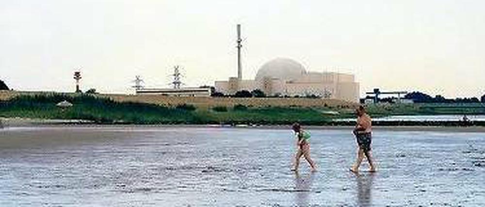 Das runde Ding (hinten) soll 2021 abgeschaltet werden. Der Elbstrand in Brokdorf mit Atomkraftwerk.