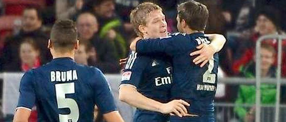 Vorlagengeber Dennis Diekmeier (r.) und Torschütze Artjoms Rudnevs (m.) feiern den Treffer zum 1:0-Endstand.