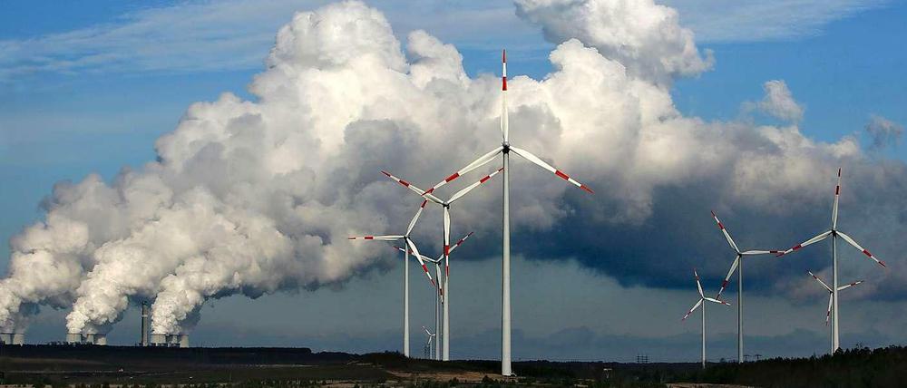 Nach der Wahl wird die Debatte über eine Reform des Erneuerbare-Energien-Gesetzes (EEG) ernsthaft geführt werden. Denn dass es Reformbedarf gibt, bezweifelt niemand. Das Foto zeigt das Braunkohlekraftwerk Jänschwalde mit Windrädern davor.