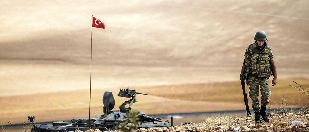 Türkischer Soldat patrouilliert neben einem Panzer an der Grenze zu Syrien