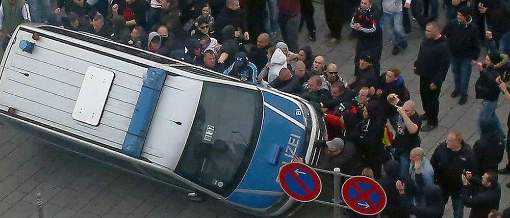 In Köln warfen die Demonstranten einen Polizeiwagen um.