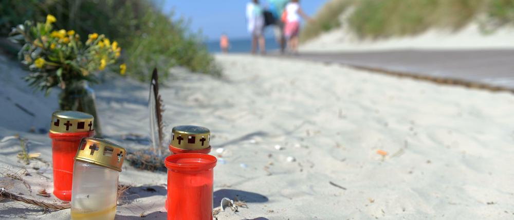 Kerzen und Blumen stehen am 05.08.2013 vor dem Aufgang zum Strand auf der Nordseeinsel Juist. Das Landgericht Aurich hatte einen 24-Jährigen wegen Totschlags zu einer Freiheitsstrafe von sieben Jahren und neun Monaten verurteilt.