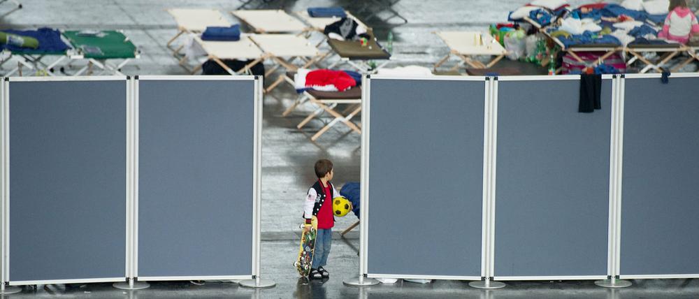 Ein Flüchtlingsjunge steht in München in der Erstaufnahmeeinrichtung für Flüchtlinge in einer Messehalle.