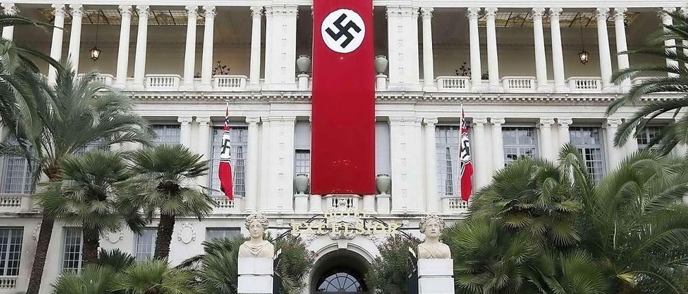 Eine Hakenkreuz-Fahne und die Wehrmacht vor dem Sitz der Präfektur in Nizza.