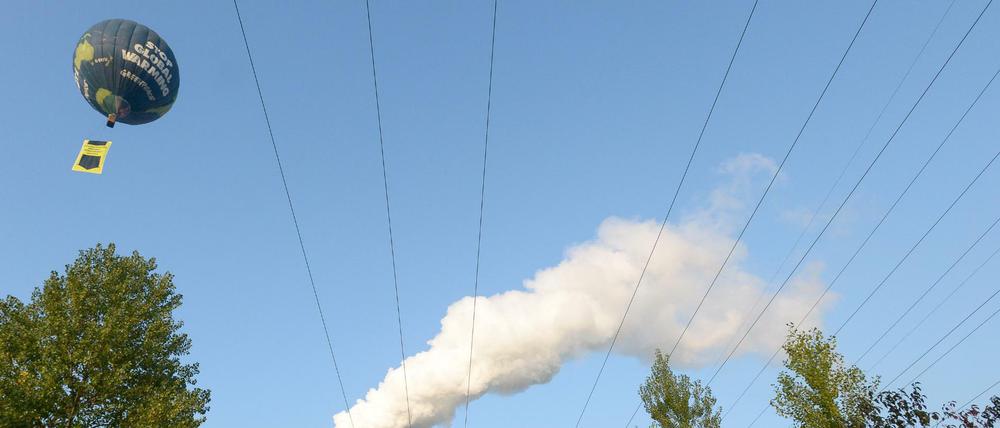 Mit einem Ballon mit der Aufschrift "Stop Global Warming" überfährt ein Heißluftballon der Umweltorganisation Greenpeace das Braunkohlekraftwerk Deuben in Sachsen-Anhalt.