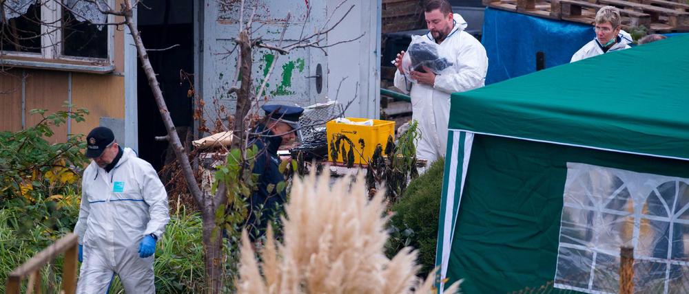Kriminaltechniker durchsuchen am Freitag eine Gartenlaube in einer Kleingartensiedlung in Luckenwalde.