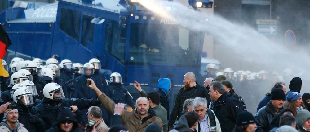 Die Polizei geht mit einem Wasserwerfer gegen die Pegida-Versammlung vor.