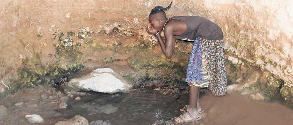 Wasser in der Wüste: Ein Himba-Junge stillt seinen Durst in einer der wenigen noch wasserspendenden Schichtquellen im Norden der Kalahari.