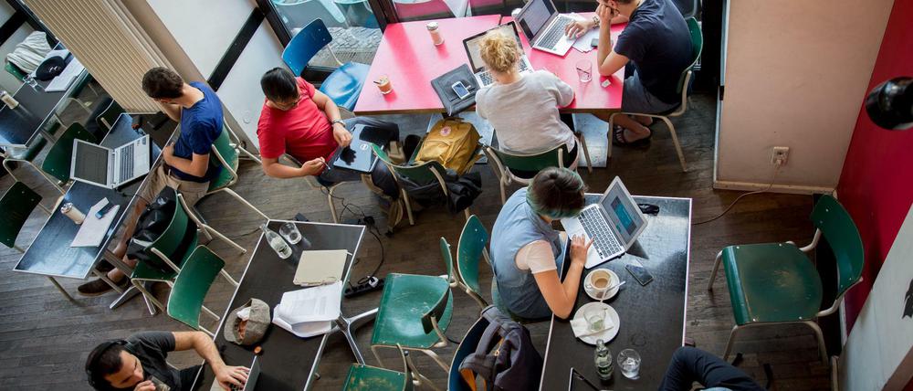 Zu Hause in den sozialen Netzwerken. Gäste im Cafe St. Oberholz an ihren Laptops.