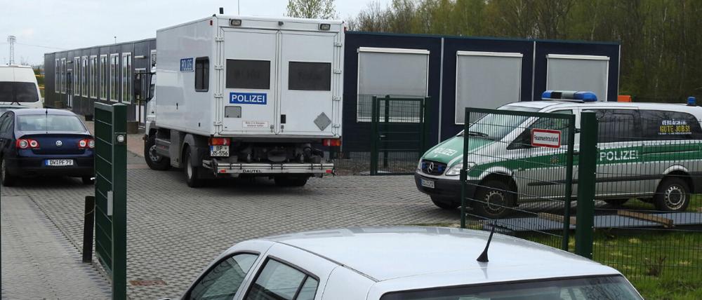Polizeiautos stehen in Borsdorf vor und auf dem Gelände eines Flüchtlingsheims, wo ein Verdächtiger festgenommen wurde.