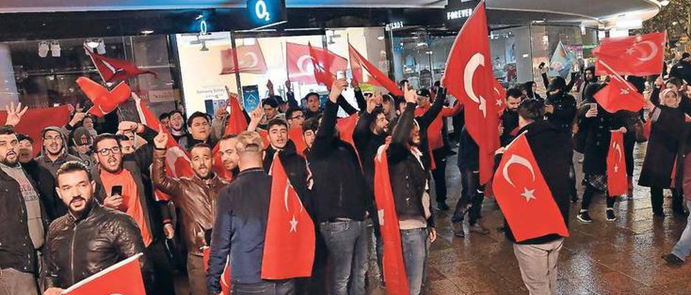 Trauer und Trubel. Deutschtürken schwenkten am Sonntagabend Fahnen auf dem Ku’damm, nachdem der Sieg des „Ja“-Lagers beim Referendums verkündet wurde. Auf der Veranstaltung der oppositionellen CHP im Theater 28 war die Stimmung gedrückt.