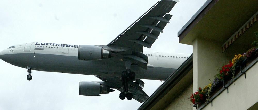 Eine Maschine Lufthansa fliegt über einem Haus im Berliner Stadtteil Reinickendorf zum Landeanflug auf den Flughafen Tegel.