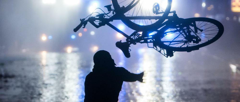 Ein Randalierer wirft während des G-20-Gipfels im Schanzenviertel ein Fahrrad in Richtung von Wasserwerfern.