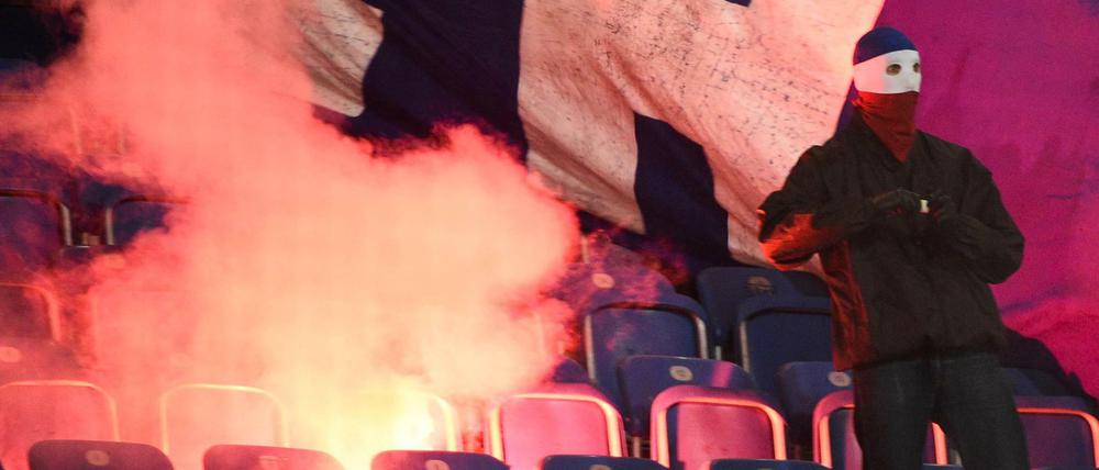 Rostocker Hooligans zünden Stadionsitze und einen Banner der Berliner an.