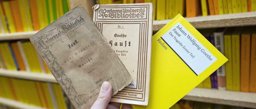 Das erste von Reclam verlegte Buch: Eine Ausgabe von Faust aus dem Jahr 1867 (links), dazu eine Ausgabe aus der Zeit des Ersten Weltkrieges und eine aktuelle Faustausgabe.
