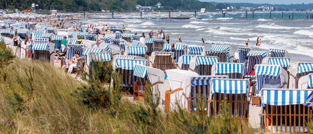 Bei Sonnenschein und starkem Wellengang ist der Ostseestrand von Timmendorfer Strand in Schleswig-Holstein gut besucht. 