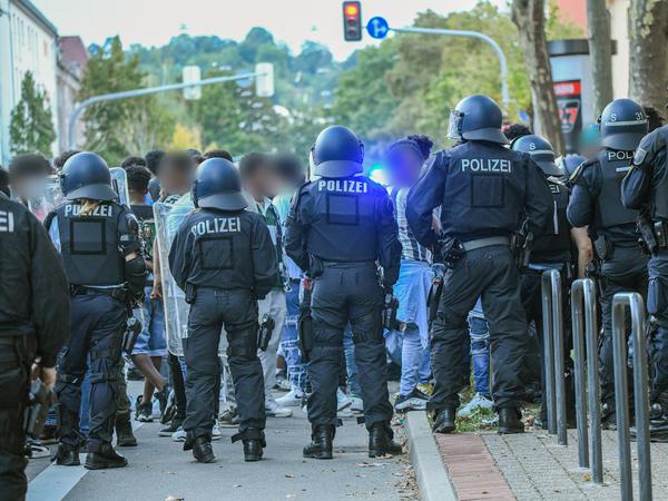 Eine Gruppe von Menschen wird nach Ausschreitungen bei einer Eritrea-Veranstaltung in Stuttgart von Polizeikräften eingekesselt. 