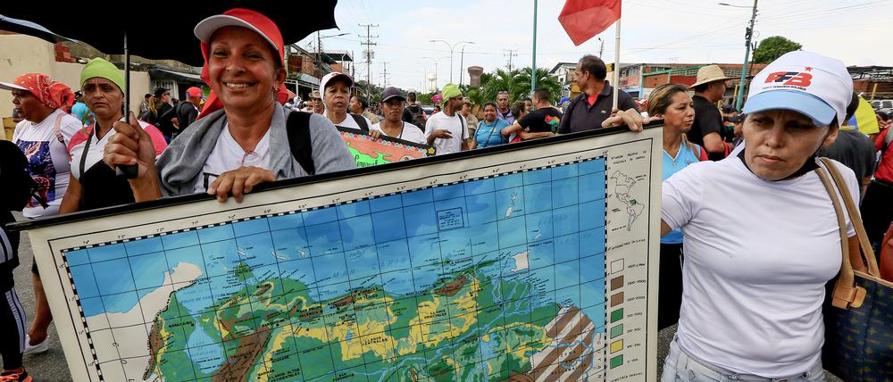 Frauen halten während einer Kundgebung für eine Volksabstimmung eine Landkarte von Venezuela, auf der das Gebiet Essequibo des Nachbarlandes gezeigt wird.
