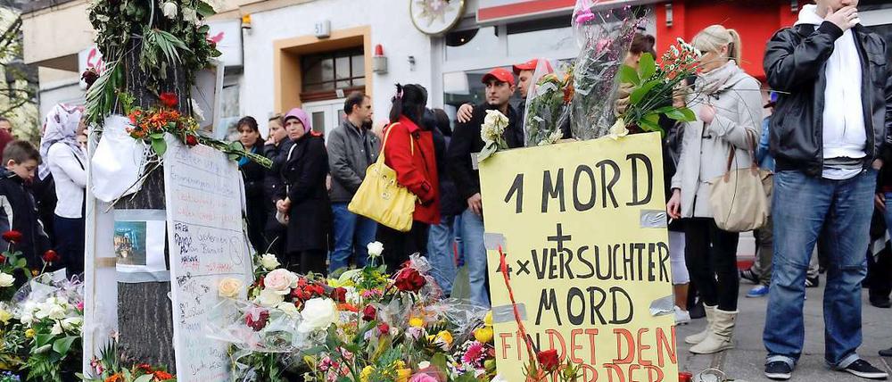 Passanten gedenken dem Opfer einer Schießerei in Neukölln.
