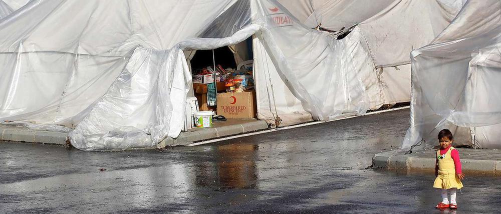 Ein syrisches Flüchtlingsmädchen steht vor Zelten des Roten Halbmondes in der türkischen Provinz Hatay.