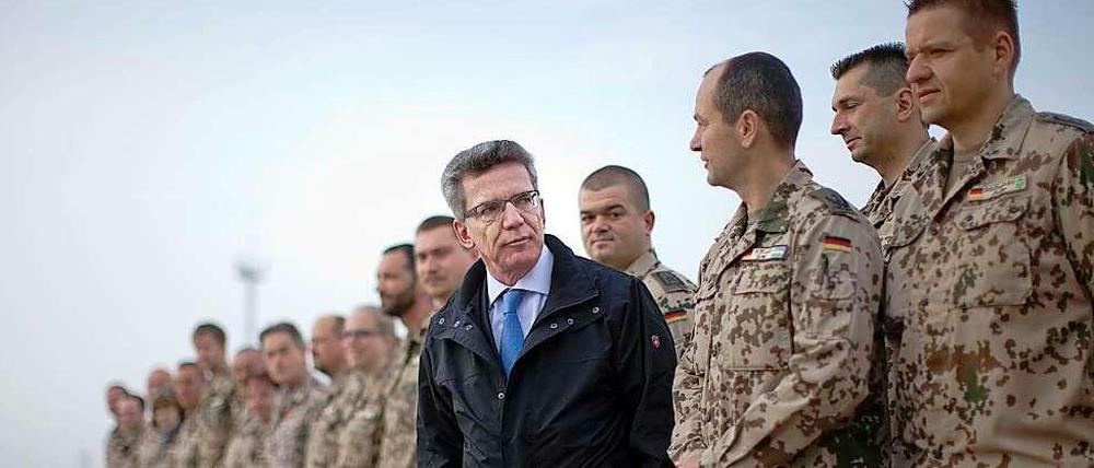 Verteidigungsminister Thomas de Maiziere spricht mit Soldaten in Usbekistan.