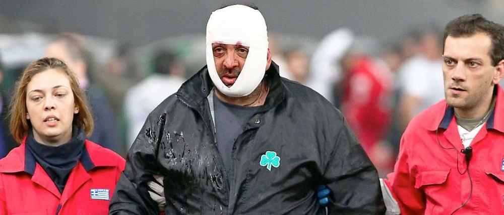 Sanitäter führen einen Verletzten nach dem eskalierten Spiel in Athen aus dem Stadion.