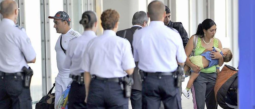 Von Polizisten überwacht erreicht die erste Gruppe "freiwilliger Roma-Rückkehrer" am Donnerstagmorgen den Saint-Exupery Flughafen in Lyon.