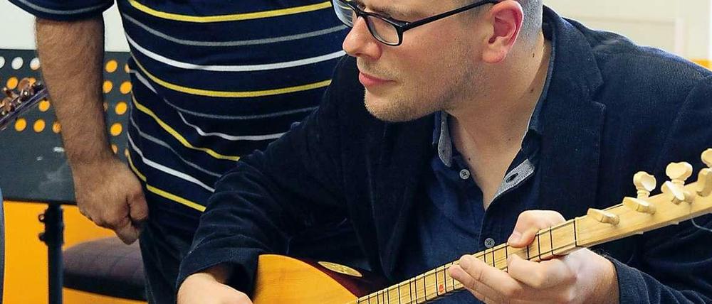 Johannes Schneider versucht sich am Saz-Spiel.