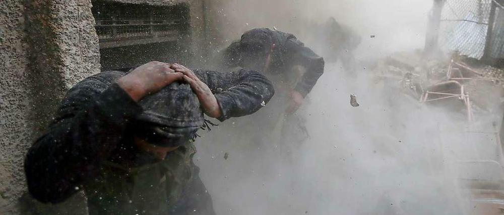 Rebellen der Freien Syrischen Armee (FSA) suchen Schutz während einer Explosion im Damaszener Ostviertel Ain Tarma.