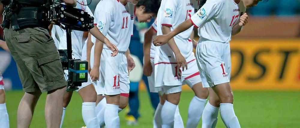 Die Kameras sind auf sie gerichtet, ihr Blick aber geht nach unten: Zwei nordkoreanische Spielerinnen wurden positiv getestet, die ganze Mannschaft steht nun unter Verdacht.