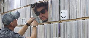 Ein Kunde zieht in einem Plattenladen in Seoul Bob Dylans Album „Infidels“  aus dem Regal.
