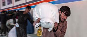 Ein Mann in Kabul schleppt einen Sack mit Lebensmitteln von einer Hilfsorganisation in Kabul. 