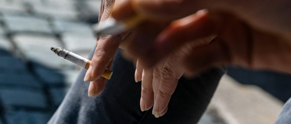 Raucher halten brennende Zigaretten in der Hand.