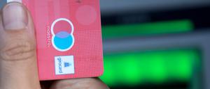 Eine Bankkundin hebt mit ihrer Girokarte, mit rot-blauem Maestro-Logo, Bargeld von einem Geldautomaten ab. Das Logo soll von den Girokarten verschwinden.
