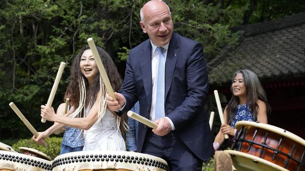 Kai Wegner, Regierender Bürgermeister von Berlin, versucht in der Residenz des deutschen Botschafters in Tokio die traditionelle japanische Trommel Taiko zu spielen.