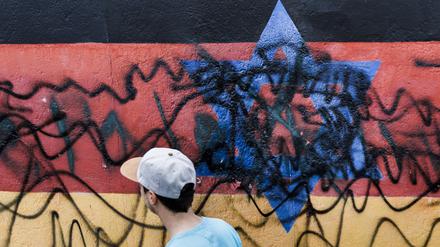 Ein Wandbild des Künstlers Günther Schäfer an der East Side Gallery mit Deutschlandfahne mit einem blauem Davidstern  wurde von Unbekannten mit schwarzen Graffitis beschmiert.