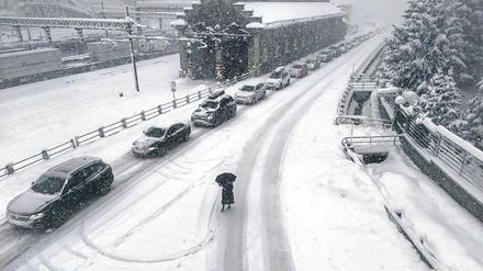 Eingeschneite Autos stehen auf der Brenner-Autobahn im Stau. 