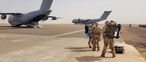 Bundeswehrsoldaten stehen vor Transportmaschinen der Bundeswehr, um mit den Fliegern Mali zu verlassen.
