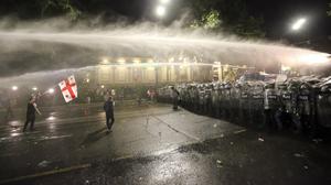 Bereitschaftspolizei setzt einen Wasserwerfer während eines Protestes der Opposition gegen das „russische Gesetz“ in der Nähe des Parlamentsgebäudes in Tiflis, Georgien, ein. 