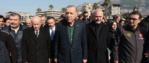 Der türkische Präsident Recep Tyyip Erdogan (Mitte) schaut sich das Ausmaß des Erdbebens in Hatay in der Türkei an.