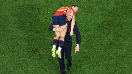 This picture taken on August 20, 2023 shows President of the Royal Spanish Football Federation Luis Rubiales carrying Spain's Athenea del Castillo Beivide on his shoulder as they celebrate winning the Australia and New Zealand 2023 Women's World Cup final football match between Spain and England at Stadium Australia in Sydney. (Photo by DAVID GRAY / AFP)