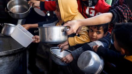 Kinder in Rafah warten auf Lebensmittel Lieferungen. 
