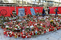 Menschen bleiben vor Kerzen und Blumen stehen, um der Opfer des Anschlags auf den Weihnachtsmarkt am Breitscheidplatz zu gedenken.